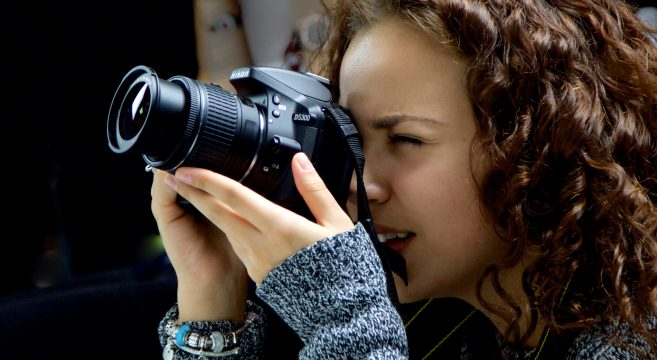 Female photography student taking a photo on a professional camera