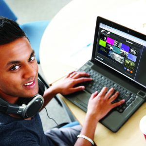 Male student looking at college website on laptop