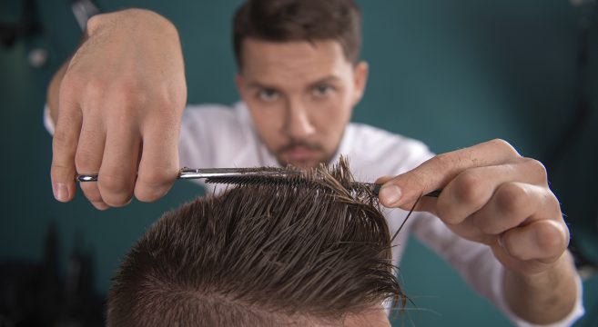Barber cutting man's hair