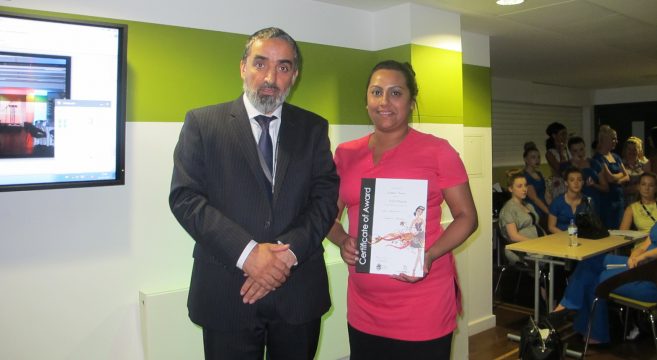 Beauty student presented with certificate by college manager