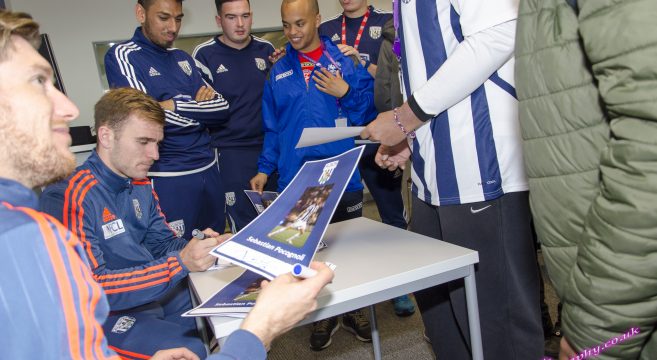 WBA players signing autographs for students