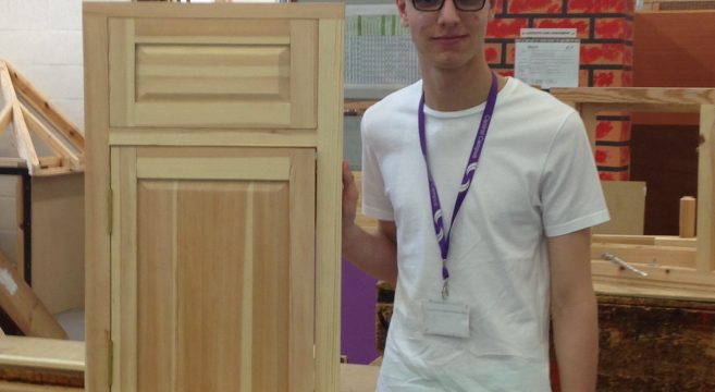 Carpentry student with kitchen cupboard door