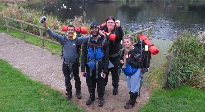 Group of students stood by a lake