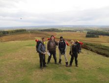 Four students standing on a hill wearing expedition gear