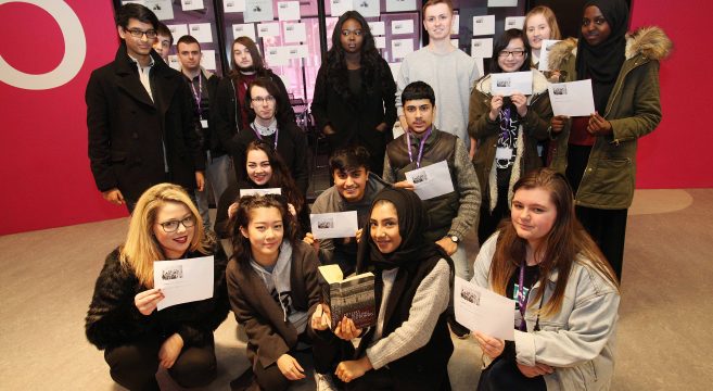 Group of students holding up worksheets