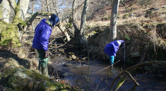 Two students measuring river