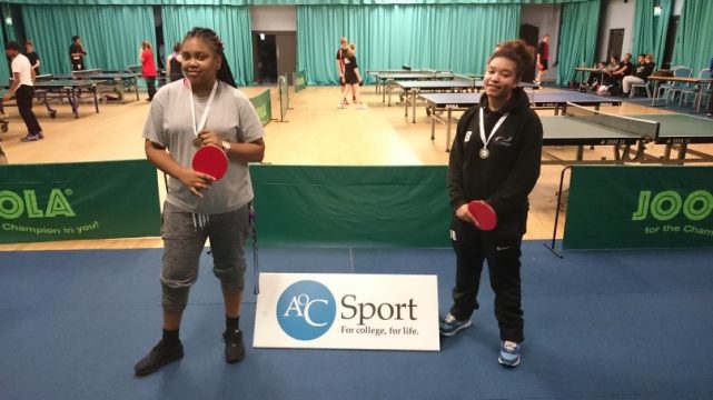 Two female table tennis players with bats