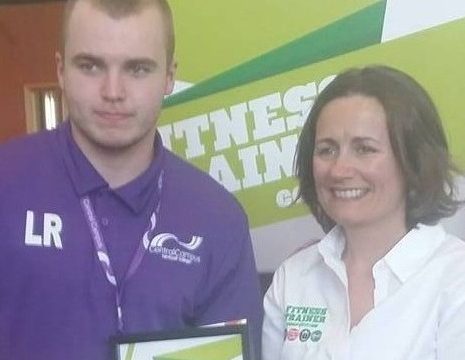 Sports student presented with certificate by female fitness trainer
