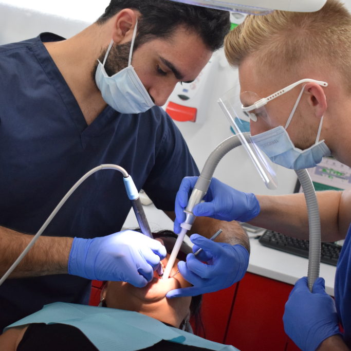 Male dental student operating on a patient