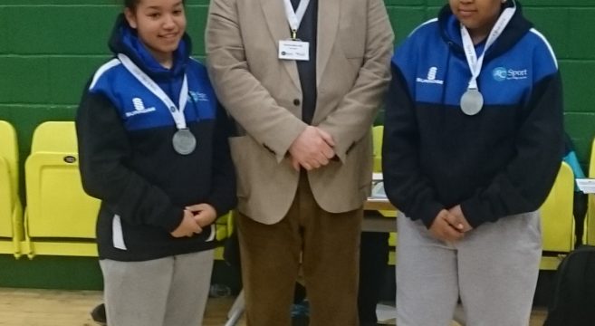 Jade & Roisin table tennis winners showing their medals pictured with member of staff