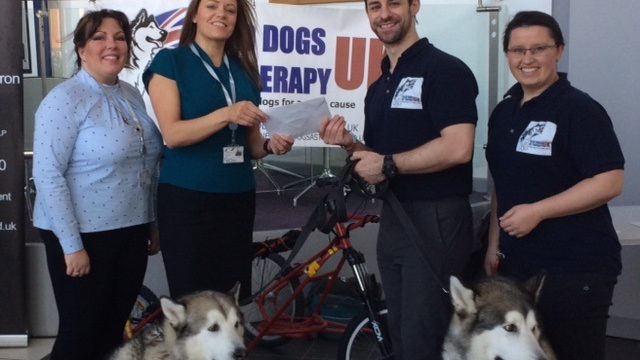 Sandwell College staff members giving cheque to representatives of Sled Dogs charity