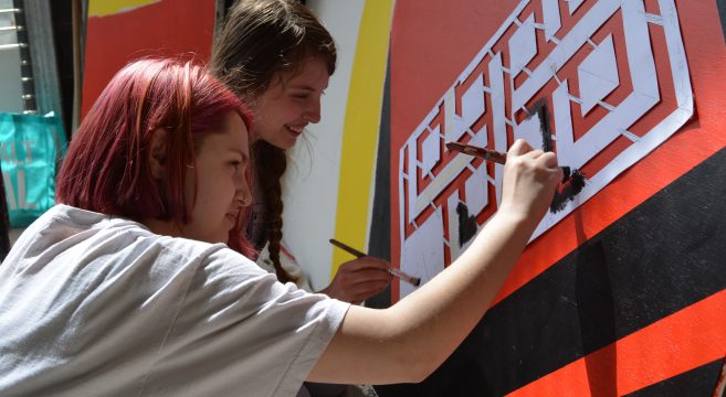 Two art students preparing a mural