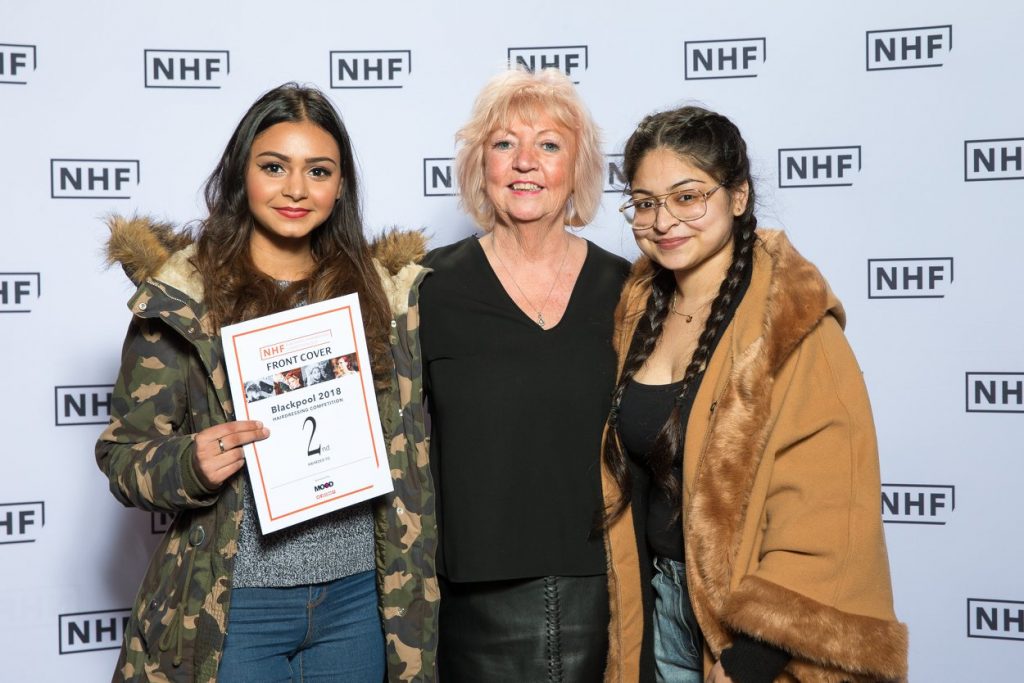 Teacher with two students holding her award