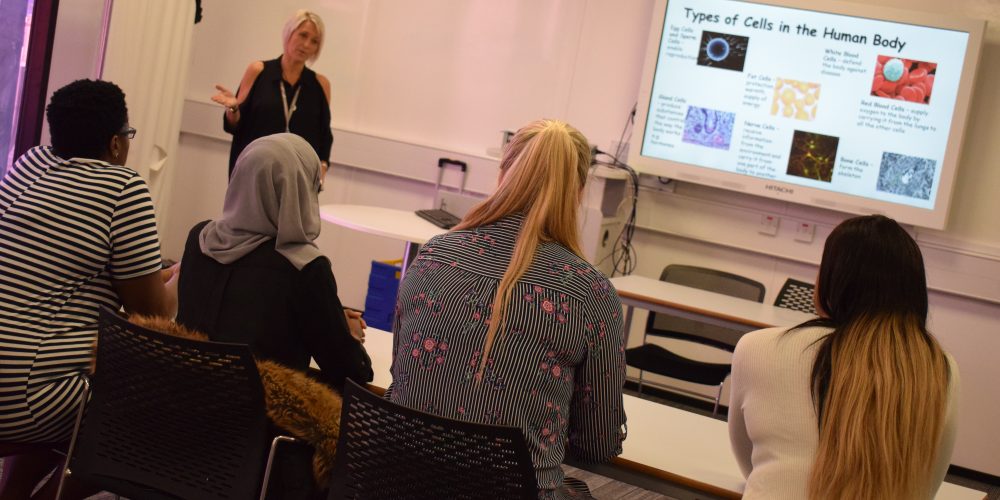 Female Health and Social Care teacher speaking to class of adult students