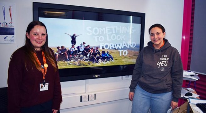 National Citizen Service representatives pictured in front of a television
