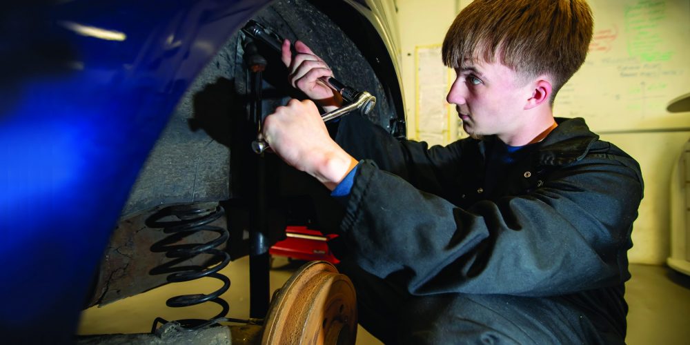 Automotive Student working on the wheel of a car