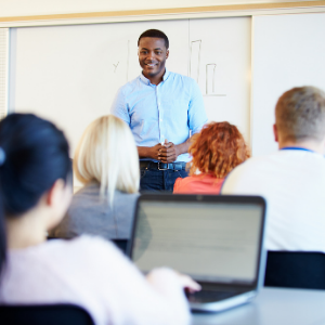 Male teacher in a classroom with adult students