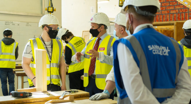 Pictured: Keir Starmer talking to students in a hard hat