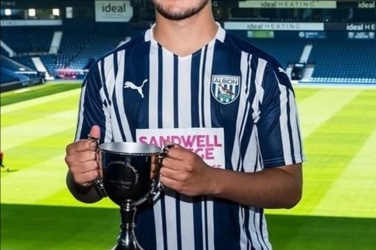 Sport student in WBA kit holding trophy at Albion ground