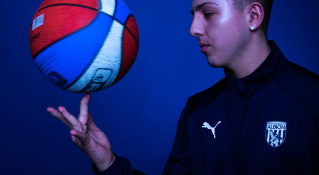 Basketball player balancing ball on one finger