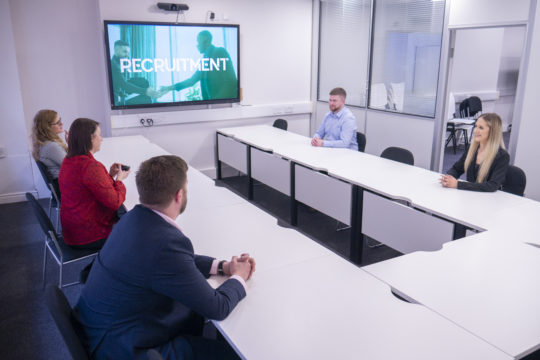 meeting room with four people talking