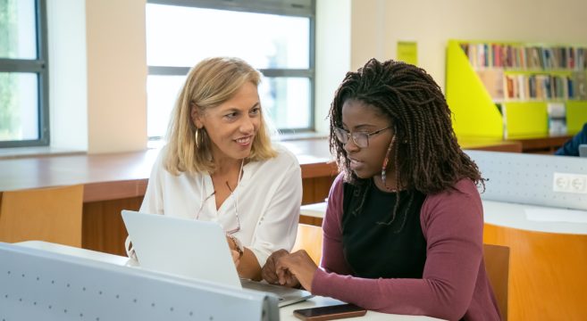 two ladies in front of laptop