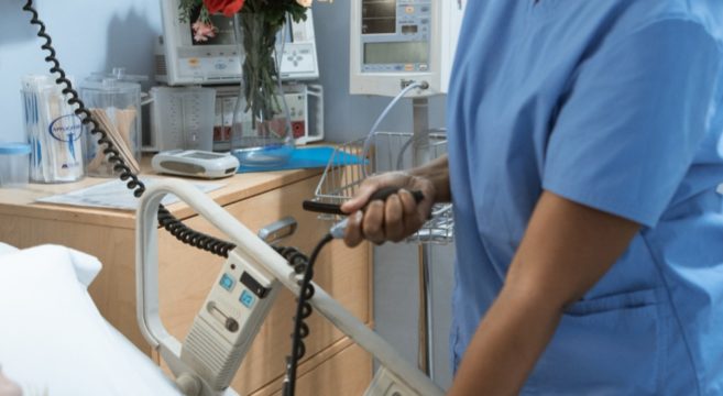 Woman caring for a patient in hospital bed