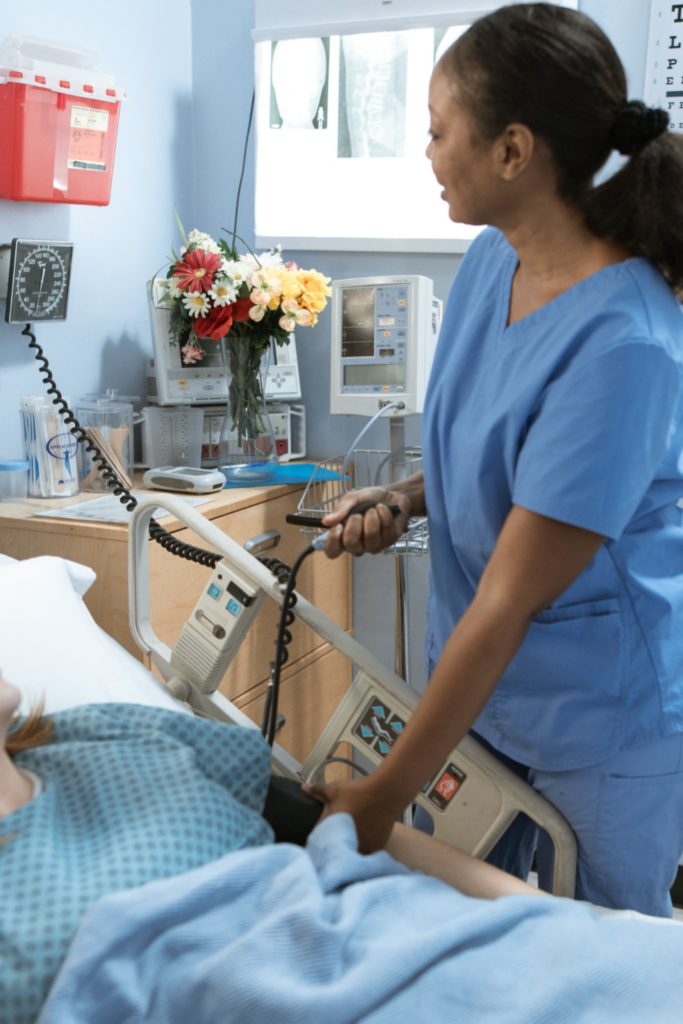 Woman caring for a patient in hospital bed