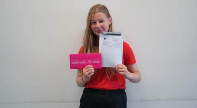 Female student holding GCSE results
