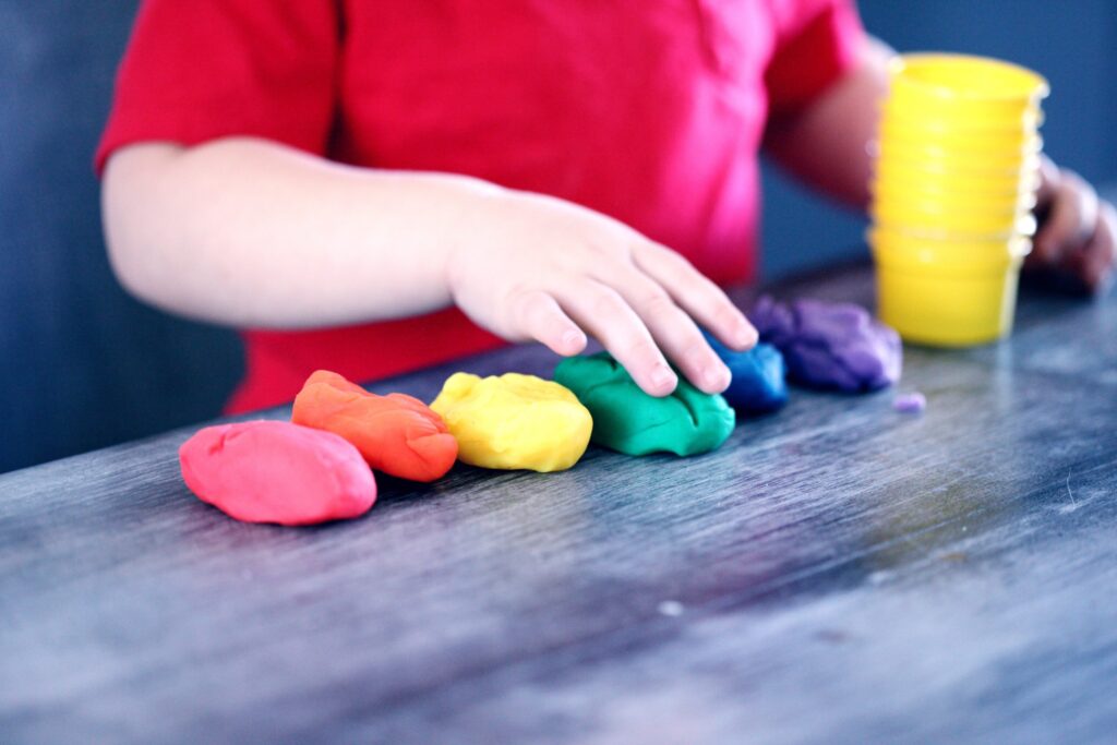 Child playing with multicoloured playdough