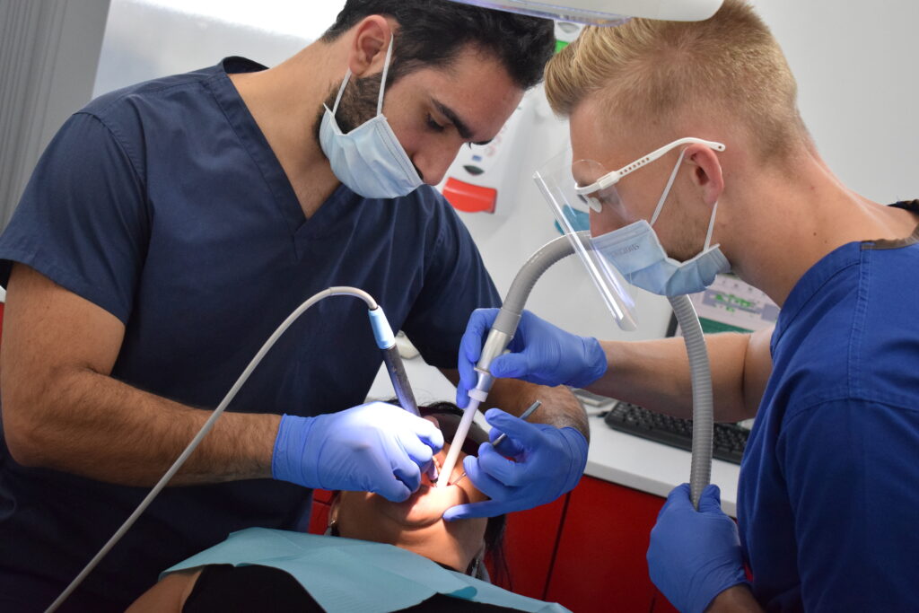 Male dental student operating on a patient