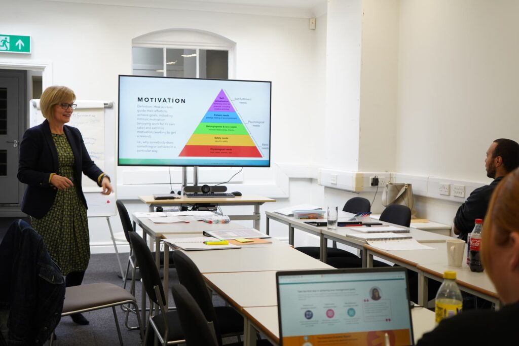 Female lecturer teaching students using screen