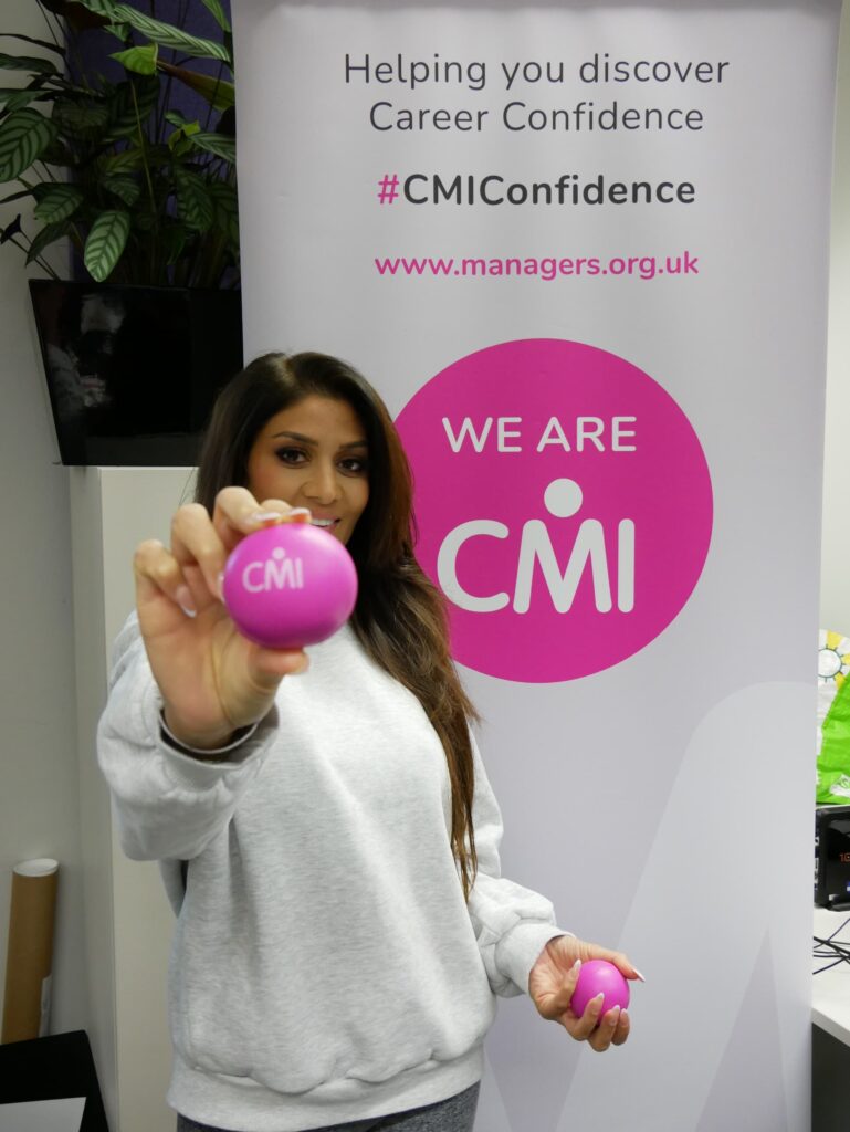 Female adult learner holding pink CMI stressballs
