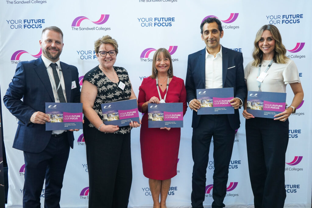 Senior Leadership Team and Governors smiling with strategy in hands