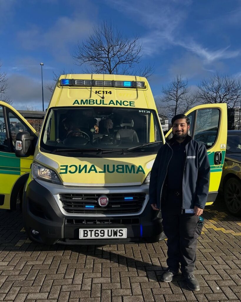 Haydar Public Services Alumni next to his ambulance