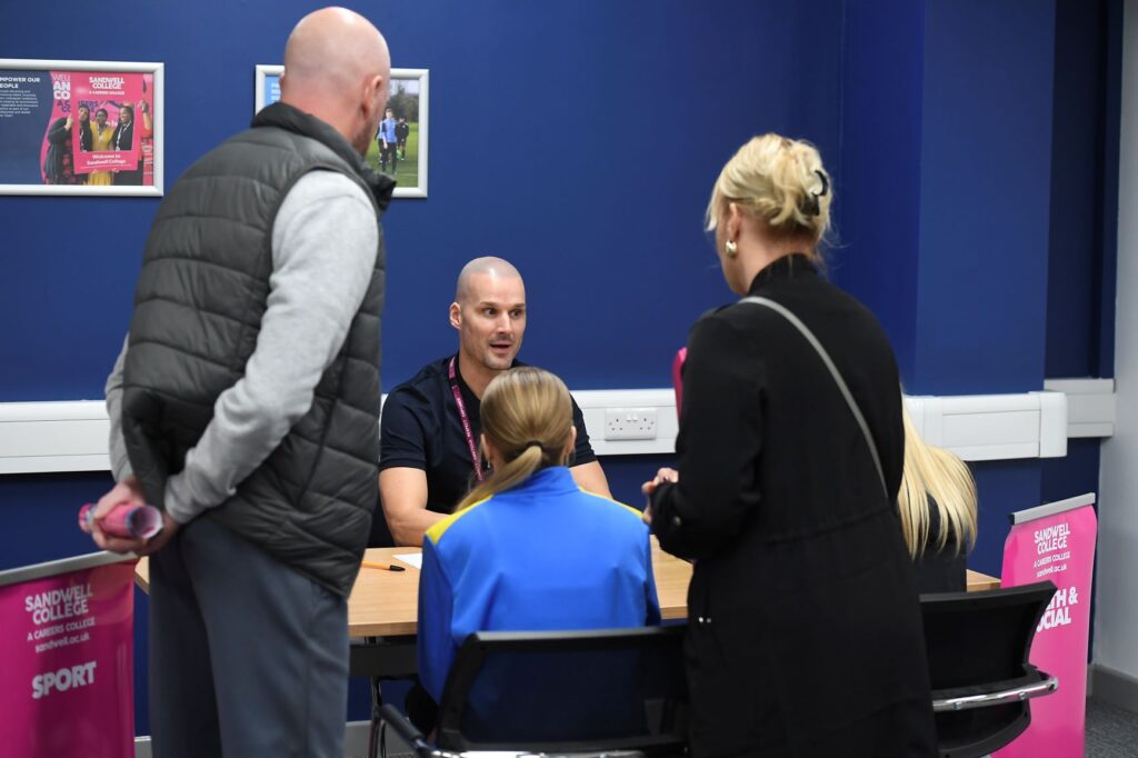 Lecturer giving advice to potential student and parents at open day