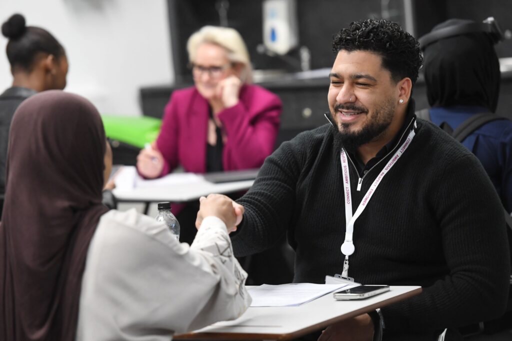 Employer shakes student's hand at interview